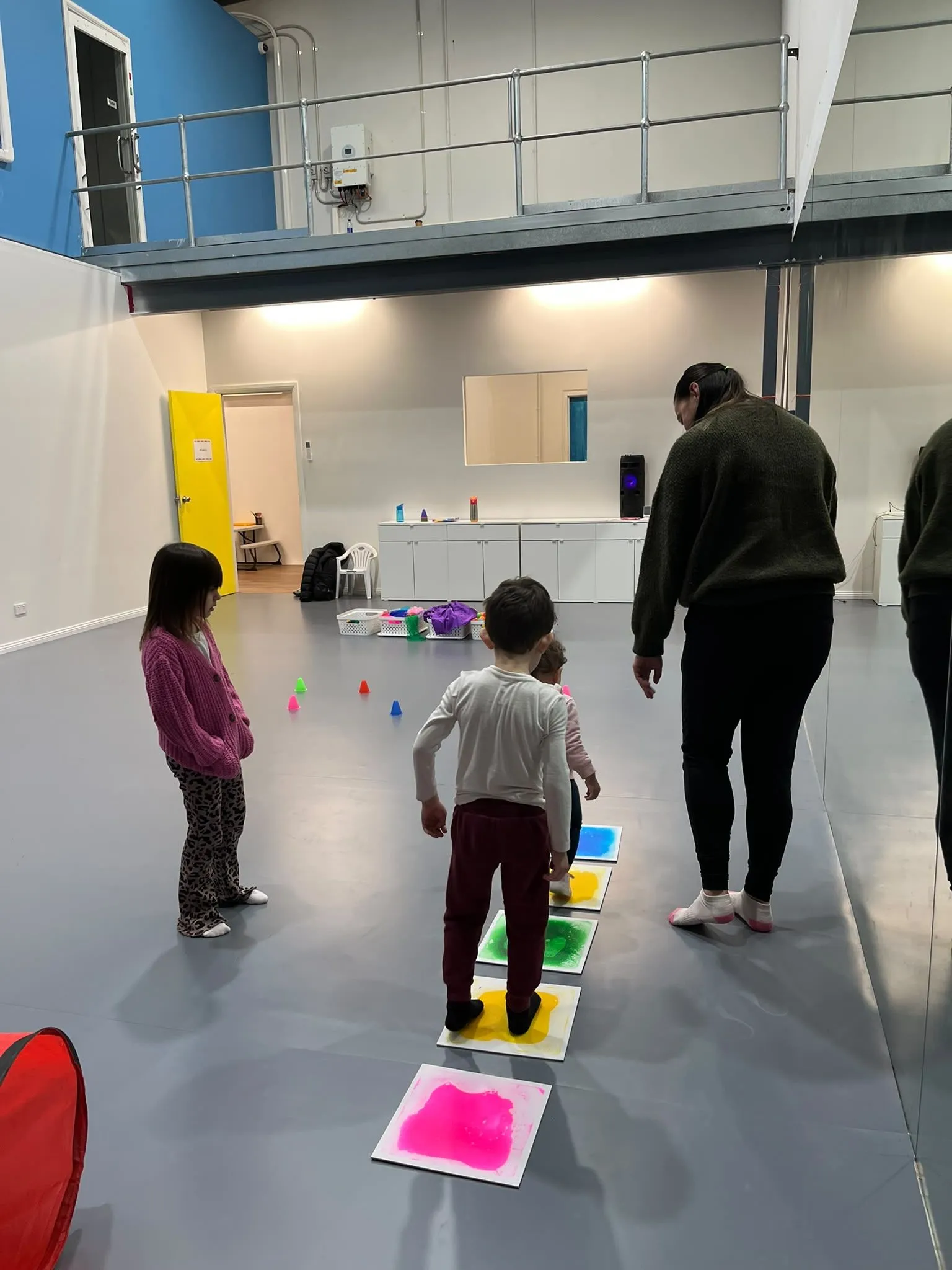 Children and an adult taking part in a colourful movement activity in the studio